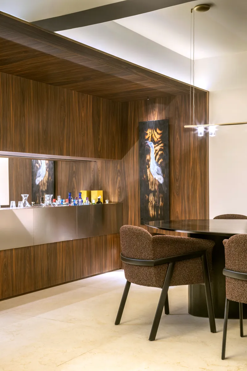 Bar com painel contínuo de marcenaria e frente em aço inox