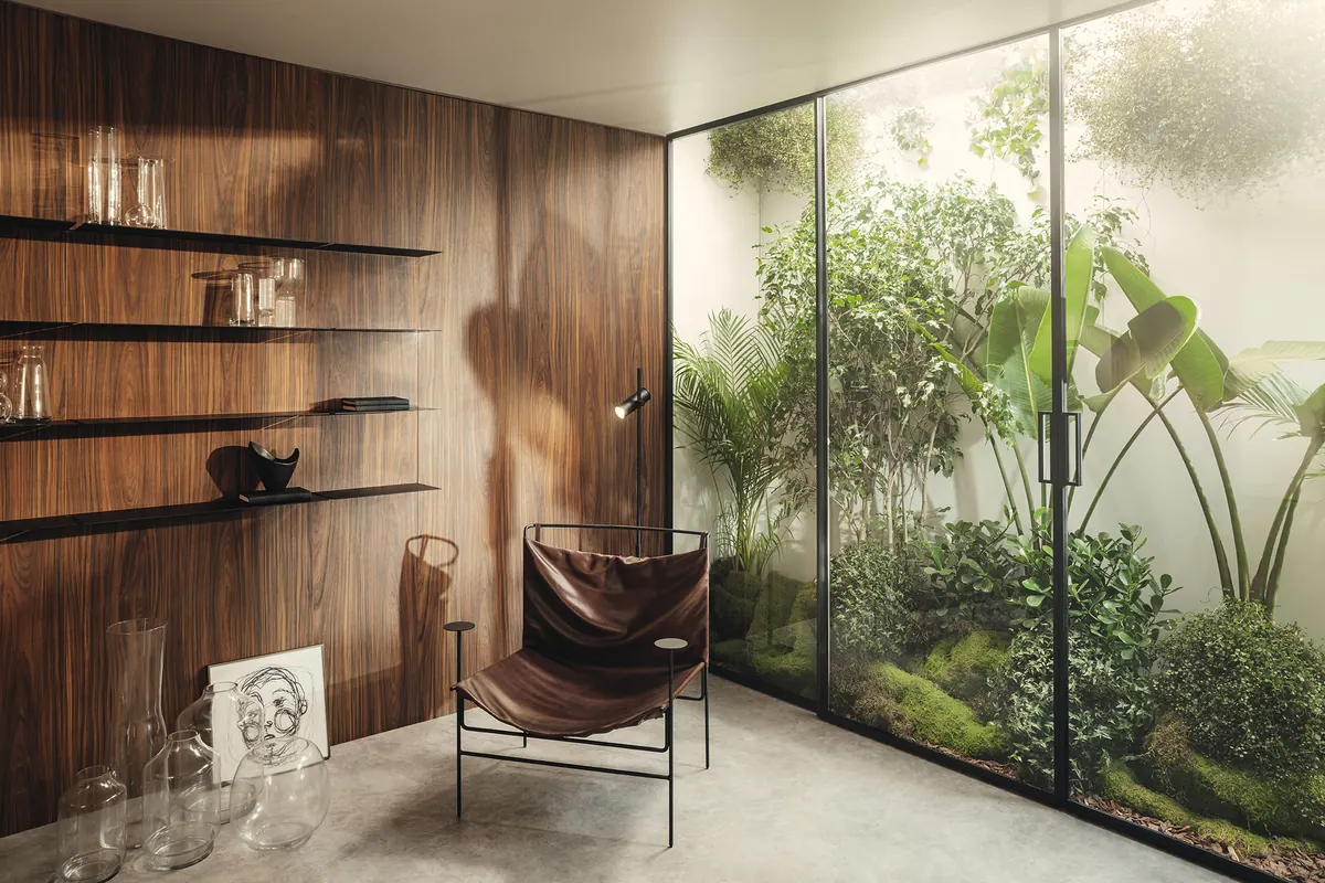 Painel de parede em tom amadeirado com prateleiras metálicas finas, assento e jardim envidraçado