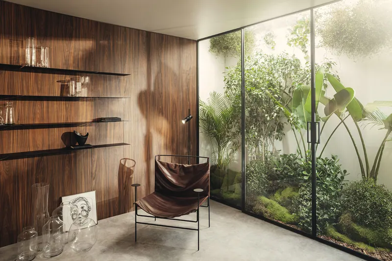 Painel de parede em tom amadeirado com prateleiras metálicas finas, assento e jardim envidraçado