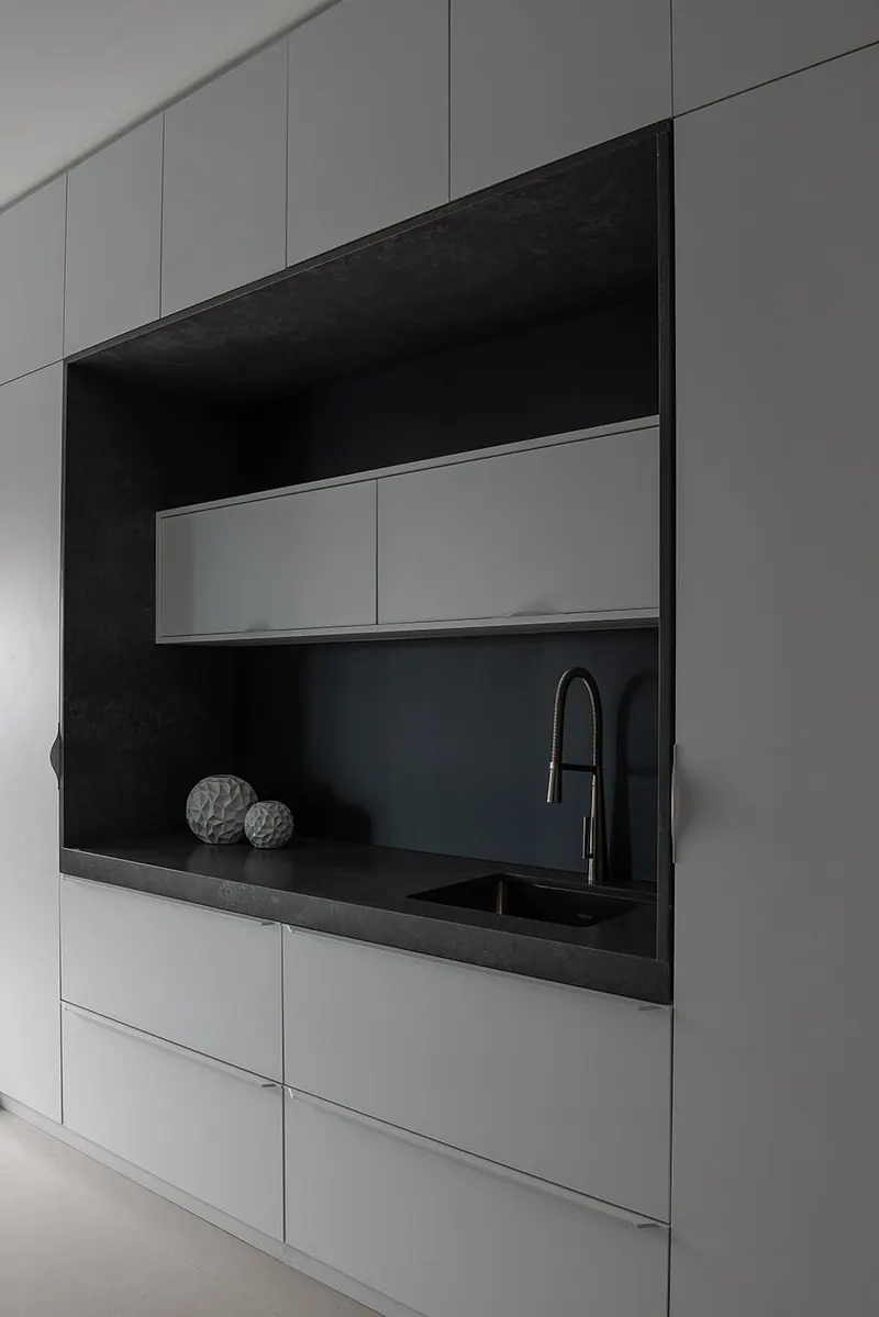 Cozinha compacta com armários cinza de portas lisas e nicho escuro com cuba e aéreo