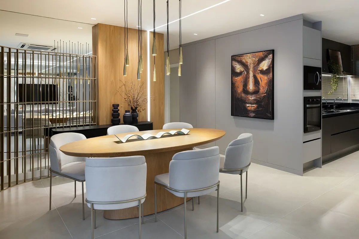Sala de jantar com painel em tom amadeirado, armários cinza sem puxador e torre quente ao fundo