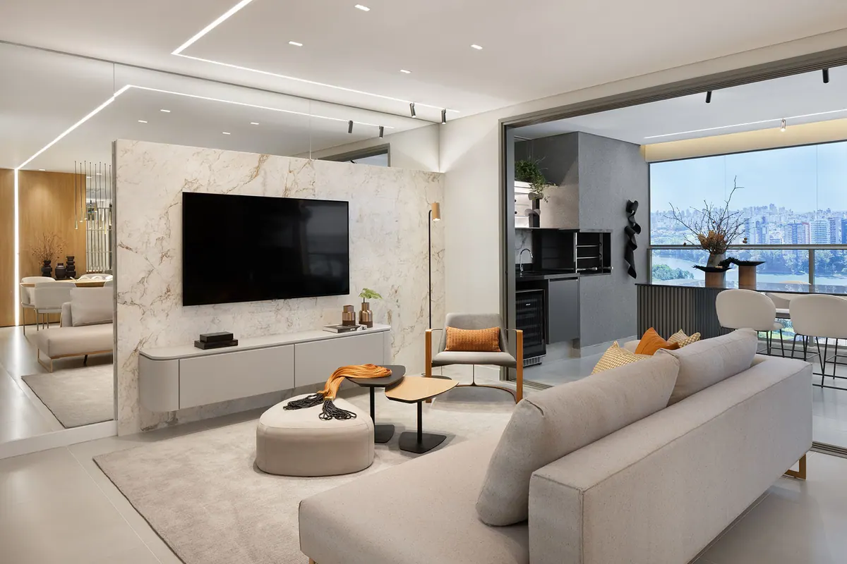 Sala com painel de televisão em pedra clara, rack suspenso com gavetas e painel amadeirado ao fundo