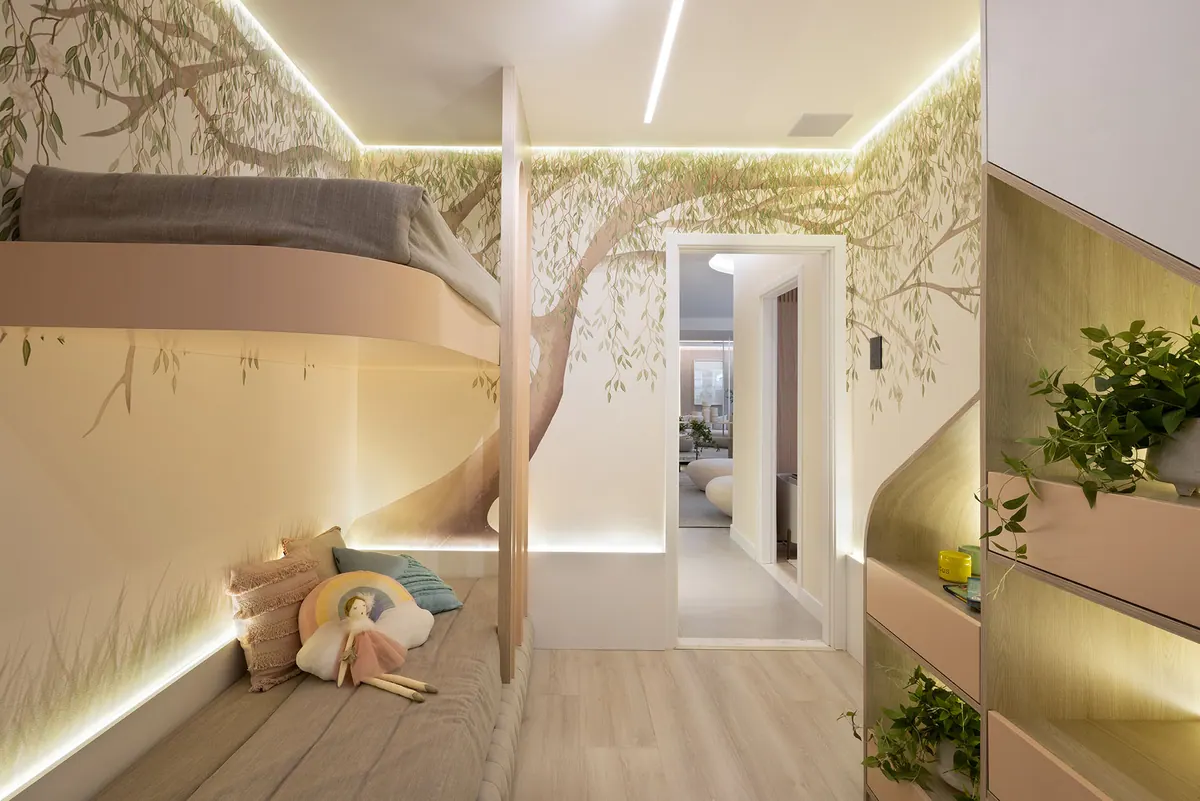 Quarto infantil com cama suspensa de frente curva, nichos iluminados na lateral e parede ilustrada