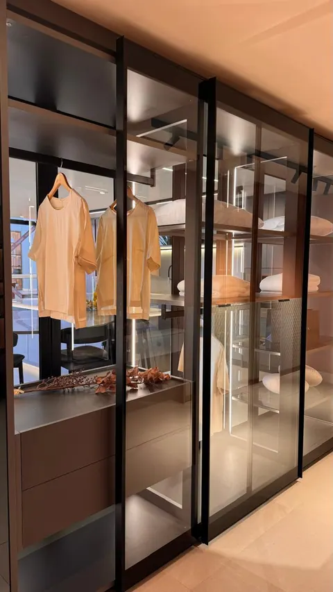 Closet com portas de vidro de correr e perfis pretos, cabideiro, prateleiras e gaveteiro interno