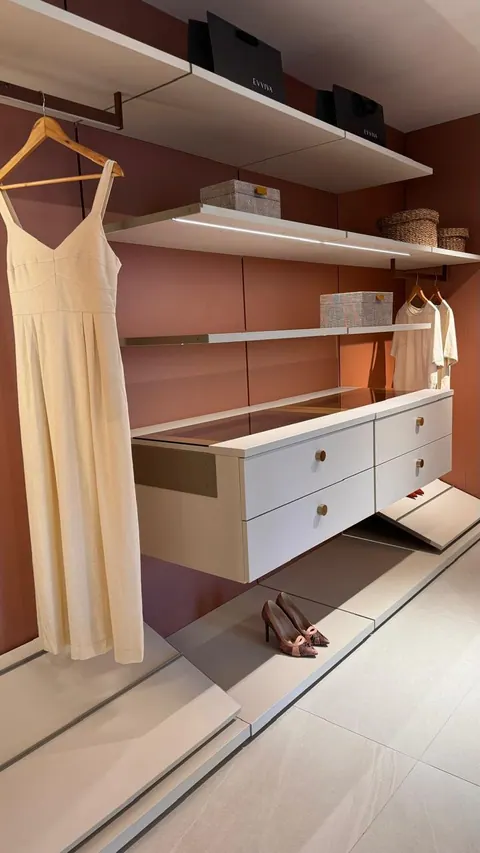 Closet aberto com painel terracota, prateleiras claras, cabideiros, gaveteiro suspenso e sapateira inclinada