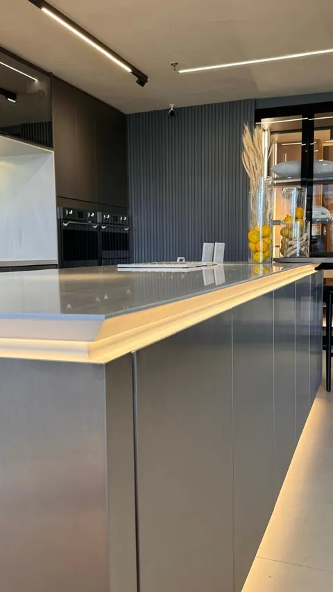 Ilha de cozinha com frentes em inox e led sob o tampo, torre quente e painel ripado