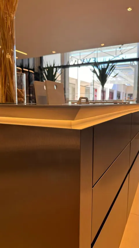 Close da quina de ilha com gavetas em inox e fita de led sob o tampo
